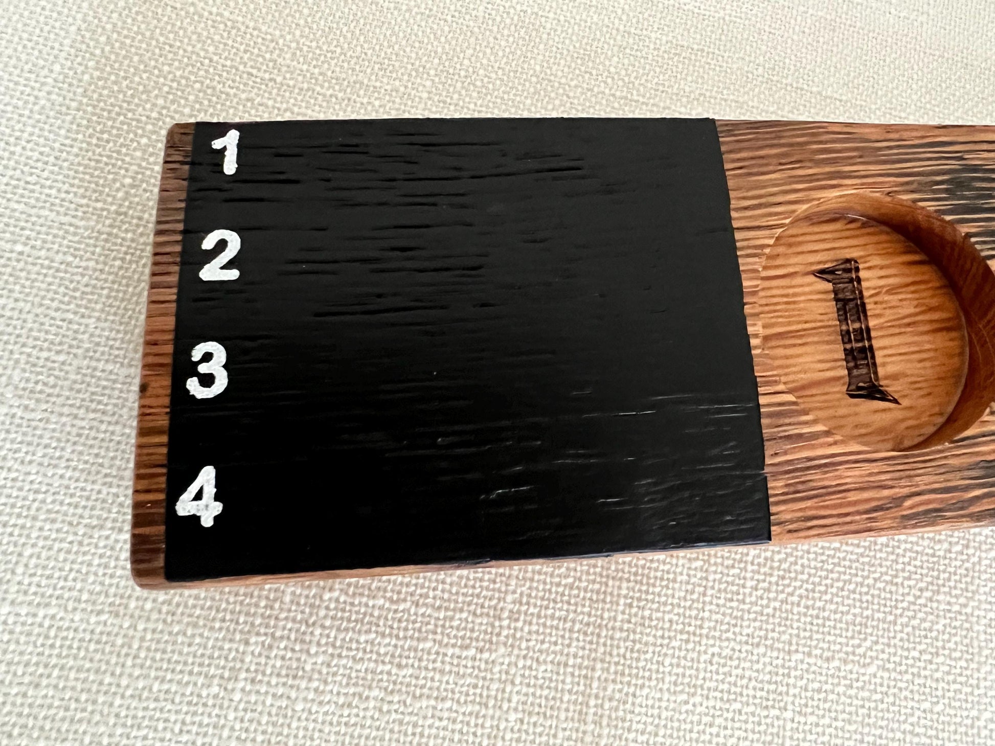 Oak wood shot flight board with four slots and a chalkboard.